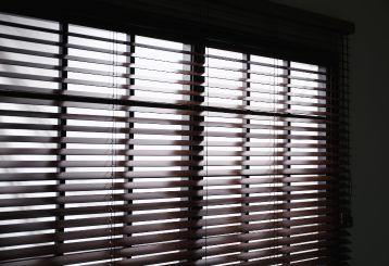 Faux wood blinds adding warmth to a living room window.