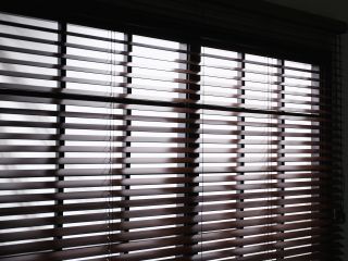 Faux wood blinds adding warmth to a living room window.