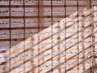 Woven Wood Shades | Laguna Niguel Blinds & Shades CA Warm and inviting living room with natural woven wood blinds, providing a touch of nature to the space.